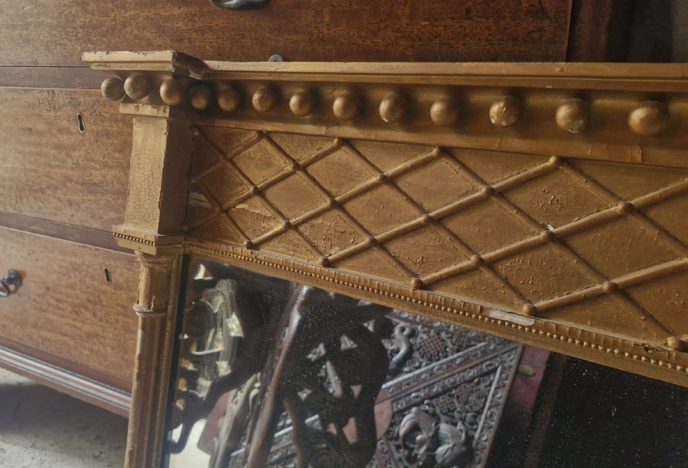 A 19th-century rectangular giltwood overmantel mirror featuring a lattice frieze, ball moulding along the top cornice, and flanking fluted columns. View III