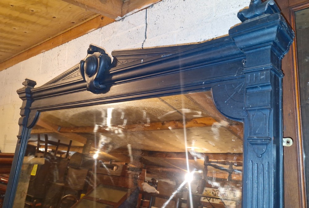 A large Victorian ebonised wooden hall mirror featuring a pedimented top with a central carved cartouche and fluted side columns. View IX