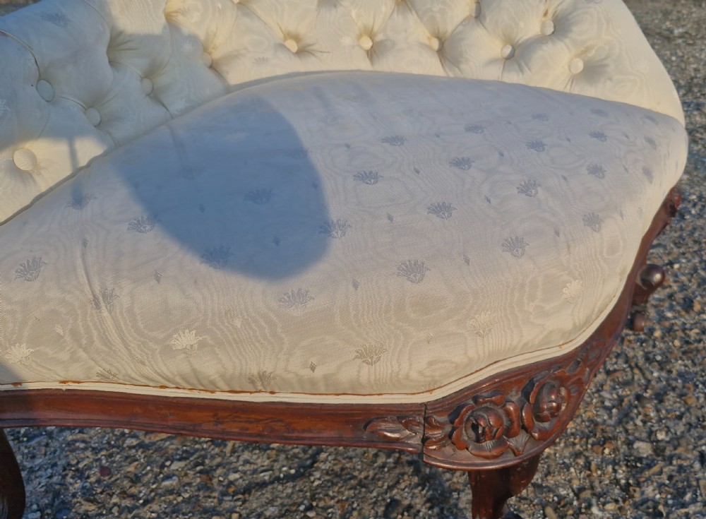 An antique Victorian corner chair featuring cream deep-buttoned damask upholstery, a carved rosewood frame with floral aprons, and curved cabriole legs on castors. View III