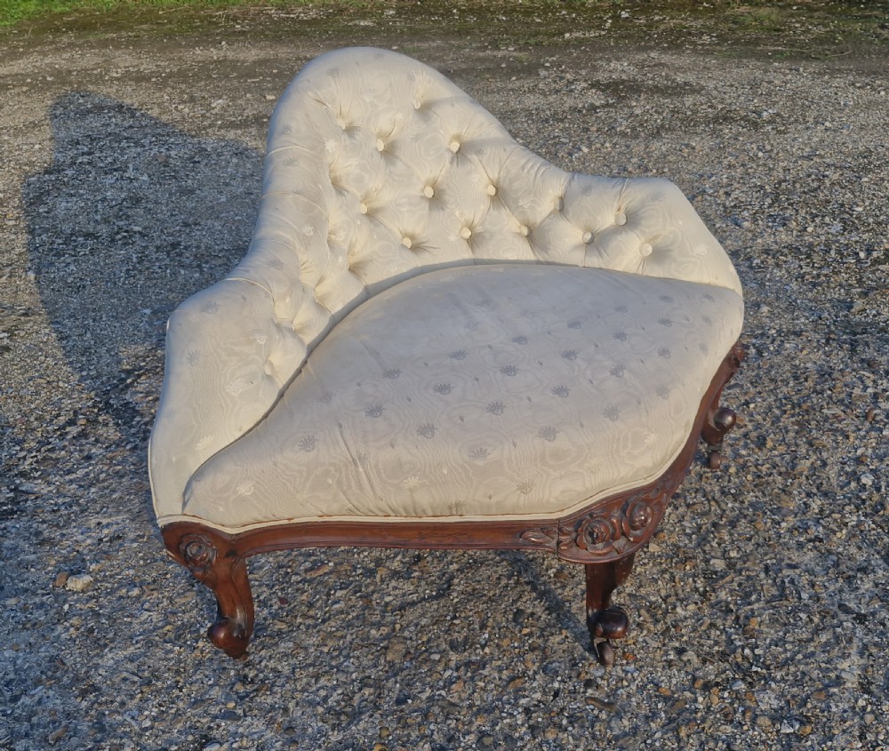 An antique Victorian corner chair featuring cream deep-buttoned damask upholstery, a carved rosewood frame with floral aprons, and curved cabriole legs on castors. View VIII