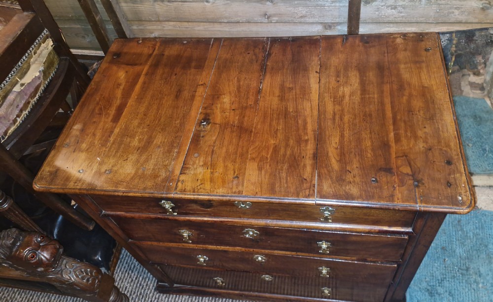 A William and Mary walnut chest featuring four graduated drawers with brass drop handles and escutcheons. View X