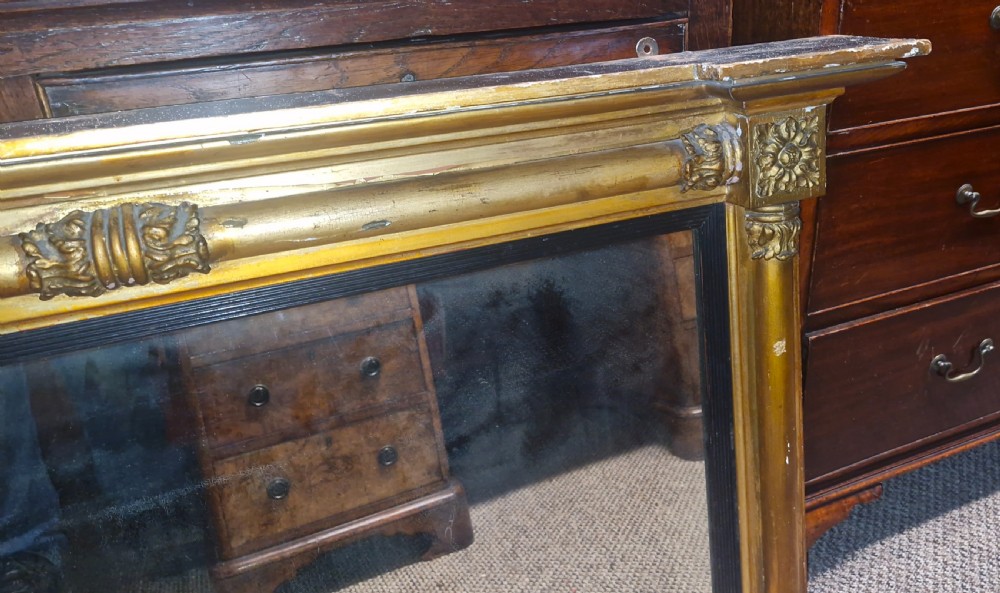 A 19th-century rectangular giltwood overmantel mirror featuring side pilasters, rosette corner mounts, and an ebonised inner slip. View III