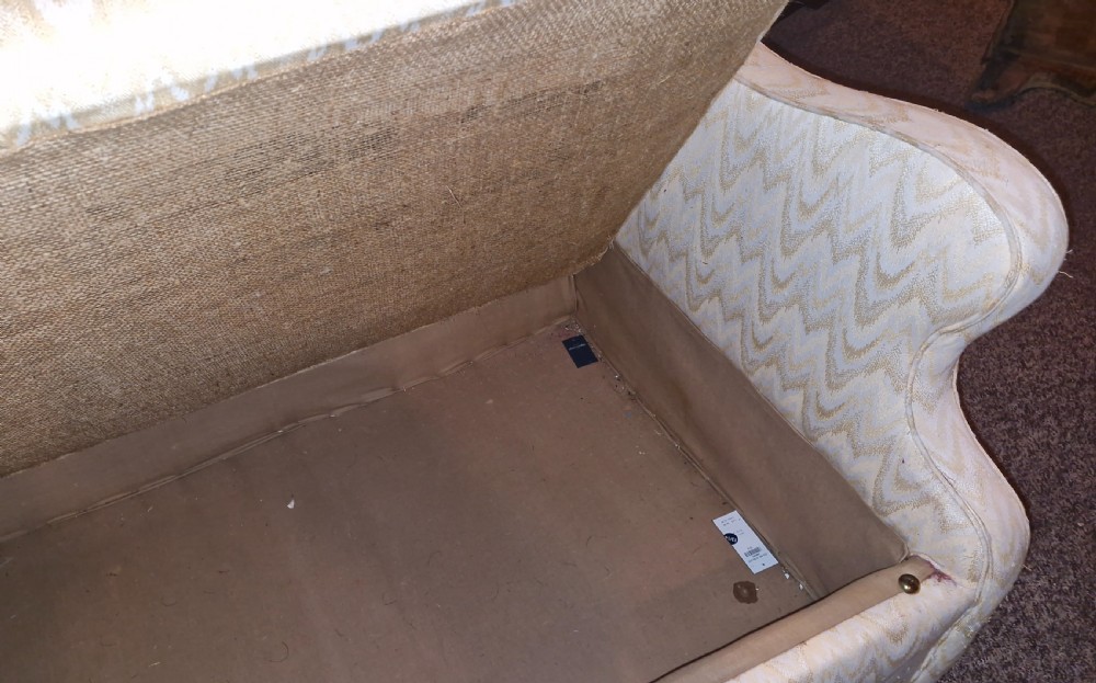 A high-backed two-seater wingback sofa upholstered in cream chevron patterned fabric with an enclosed storage box base. View II