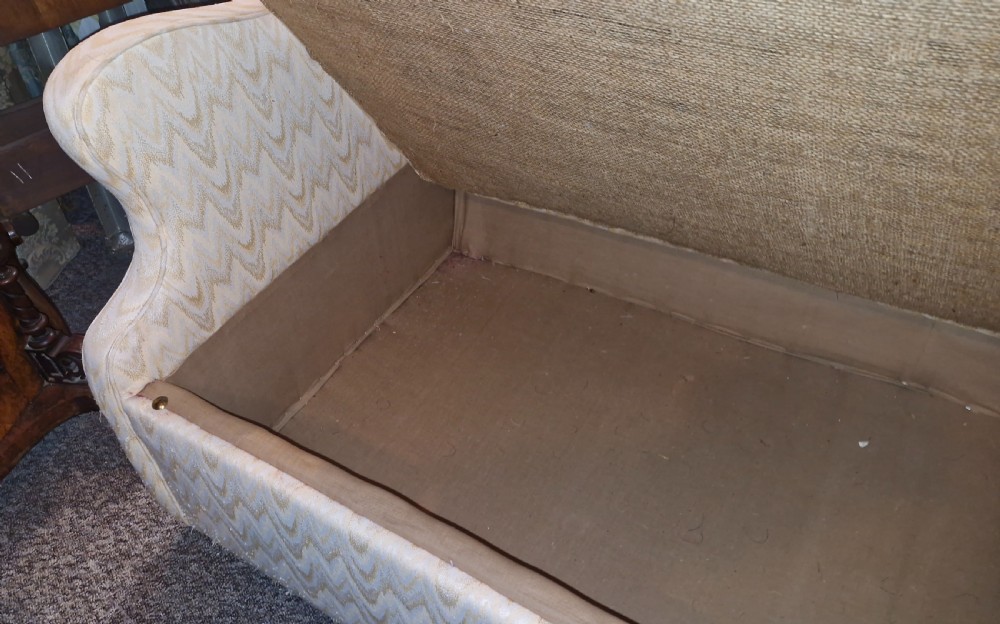 A high-backed two-seater wingback sofa upholstered in cream chevron patterned fabric with an enclosed storage box base. View IV