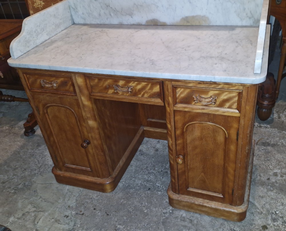 A Victorian satinbirch pedestal washstand featuring a fitted white marble surface with a raised splashback gallery and twin cupboard pedestals. View VII