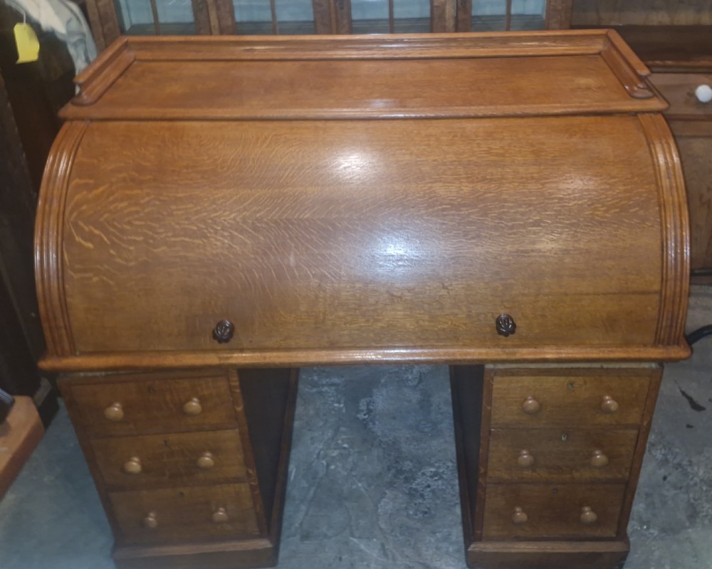 A Victorian oak cylinder top writing desk featuring a curved roll-down front and twin drawer pedestals. View XIII