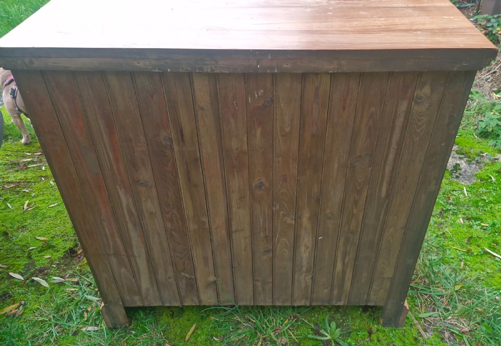 An Edwardian satin walnut chest of drawers featuring two short over three long drawers with horizontal reeded detailing and metal drop handles. View V