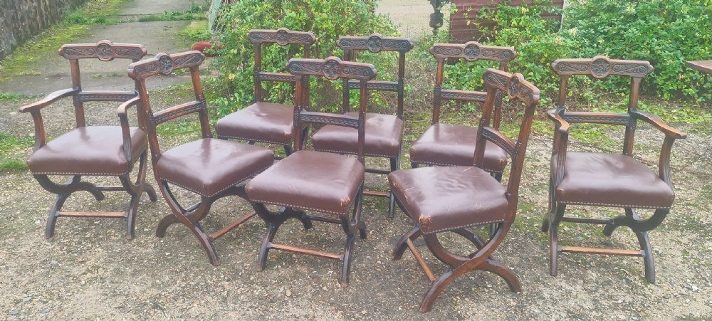 Set of 8 Victorian carved oak Gothic X frame dining chairs .