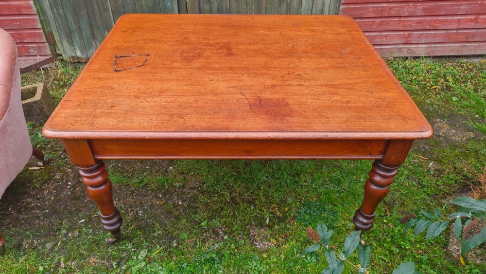 A square Victorian wooden kitchen dining table featuring turned legs fitted with brass castors. View III