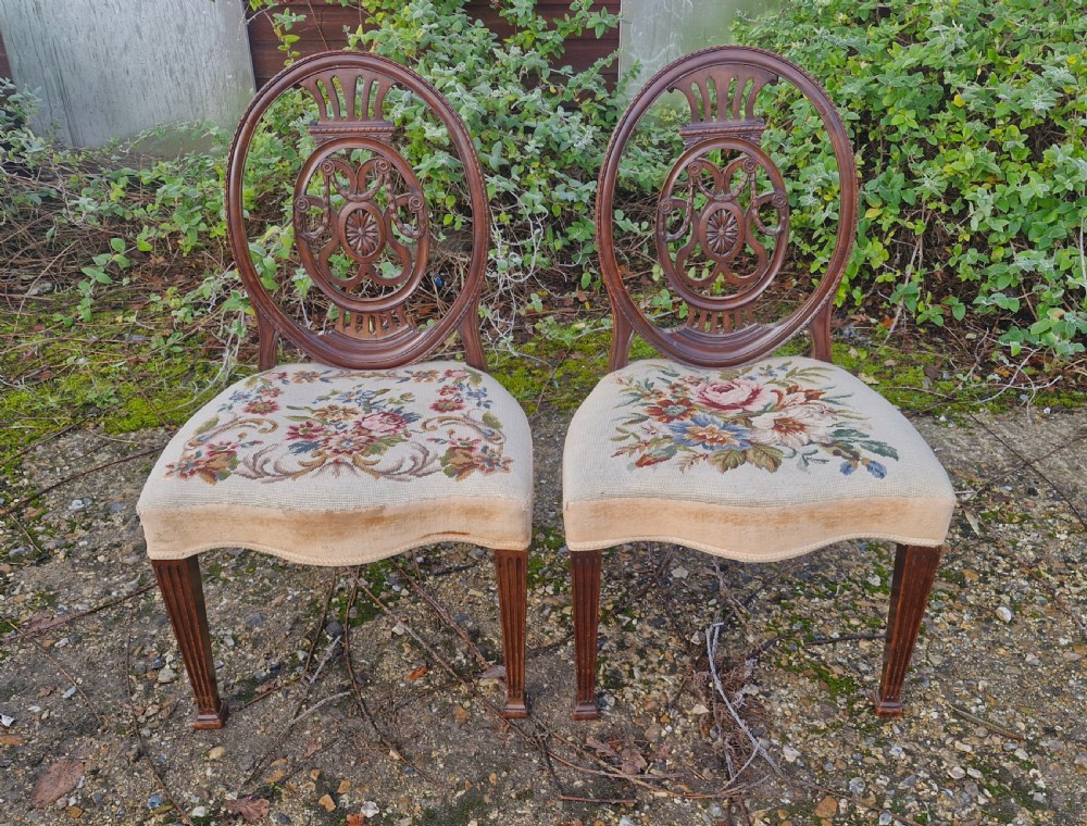 A pair of early 19th-century mahogany side chairs featuring carved oval backs, fluted legs, and floral needlepoint woolwork seats. View IV