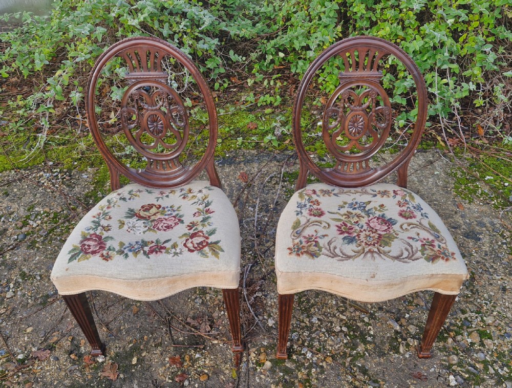 A pair of early 19th-century mahogany side chairs featuring carved oval splats and floral needlepoint upholstered seats. View II