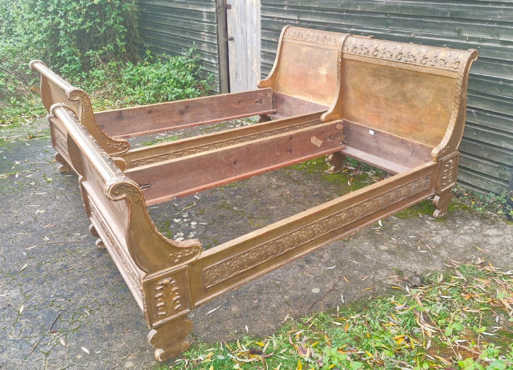 A pair of carved giltwood single sleigh beds featuring scrolled headboards, low scrolled footboards, and carved decorative friezes. View III
