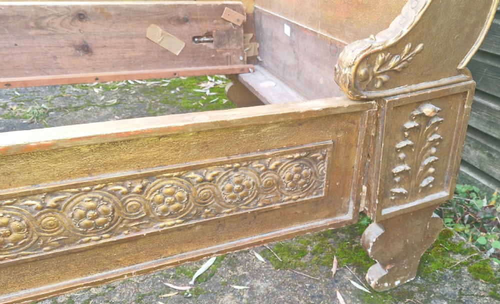 A pair of carved giltwood single sleigh beds featuring scrolled headboards, low scrolled footboards, and carved decorative friezes. View XII