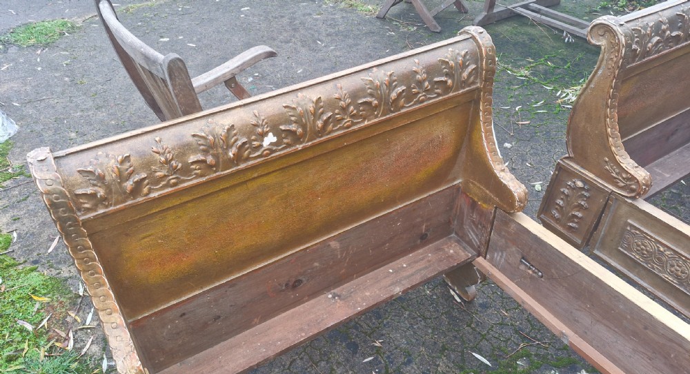 A pair of carved giltwood single sleigh beds featuring scrolled headboards, low scrolled footboards, and carved decorative friezes. View XIV
