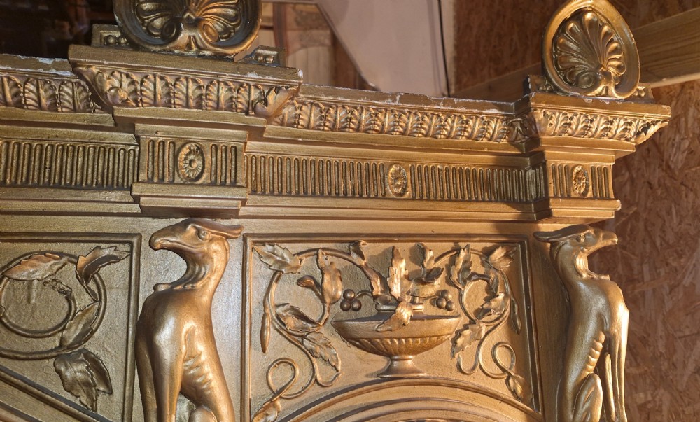 A large 19th-century gold giltwood architectural hall mirror featuring a three-panel design with ornate neoclassical columns, urn motifs, and a central medallion. View VII