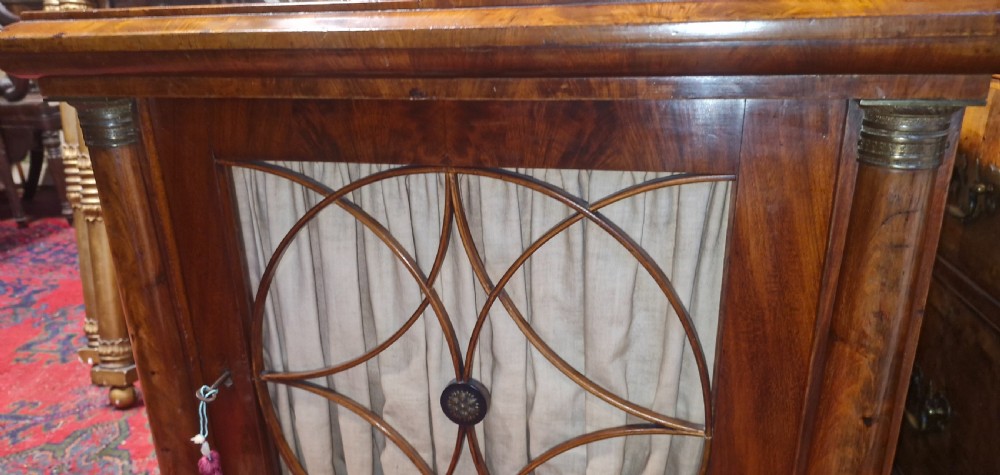 An Early Victorian mahogany single door side cabinet featuring a flame mahogany top and a decorative geometric fretwork door panel backed with fabric. View XIV
