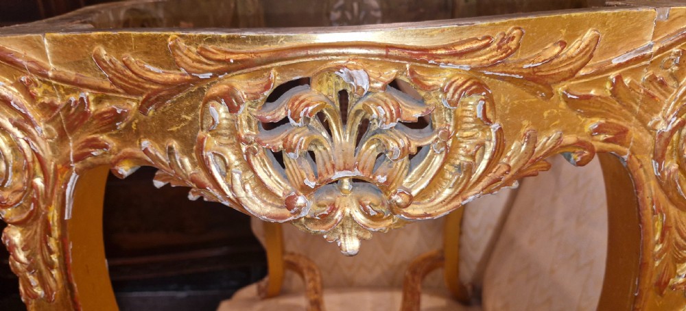 A carved giltwood occasional table featuring cabriole legs, ornate scroll carving, and a shaped veined green marble top. View XI