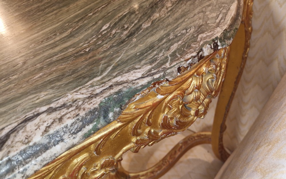 A carved giltwood occasional table featuring cabriole legs, ornate scroll carving, and a shaped veined green marble top. View XIV