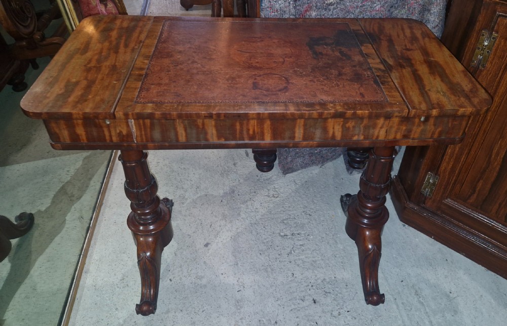 A Regency mahogany writing table featuring a central leather-inset writing surface and two hinged side flaps revealing interior storage compartments. View II