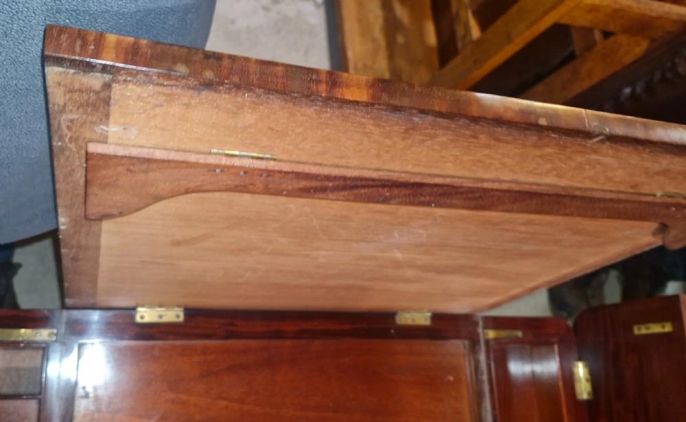 A Regency mahogany writing table featuring a central leather-inset writing surface and two hinged side flaps revealing interior storage compartments. View VII