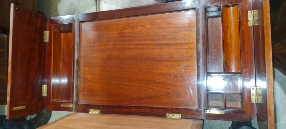 A Regency mahogany writing table featuring a central leather-inset writing surface and two hinged side flaps revealing interior storage compartments. View VIII
