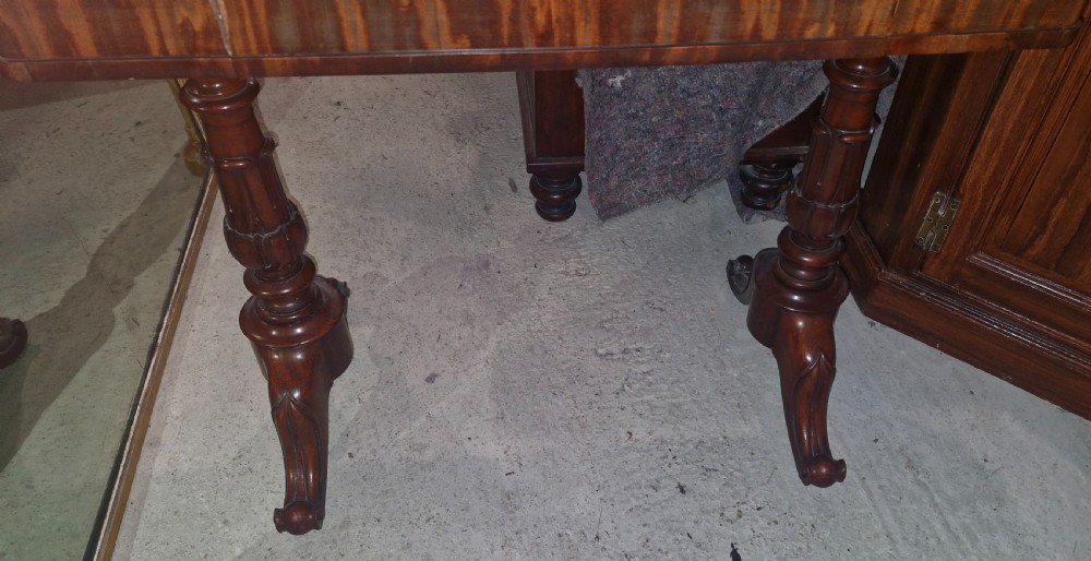 A Regency mahogany writing table featuring a central leather-inset writing surface and two hinged side flaps revealing interior storage compartments. View XV
