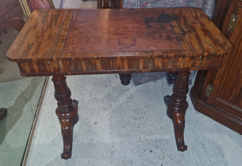 A Regency mahogany writing table featuring a central leather-inset writing surface and two hinged side flaps revealing interior storage compartments. View XVI
