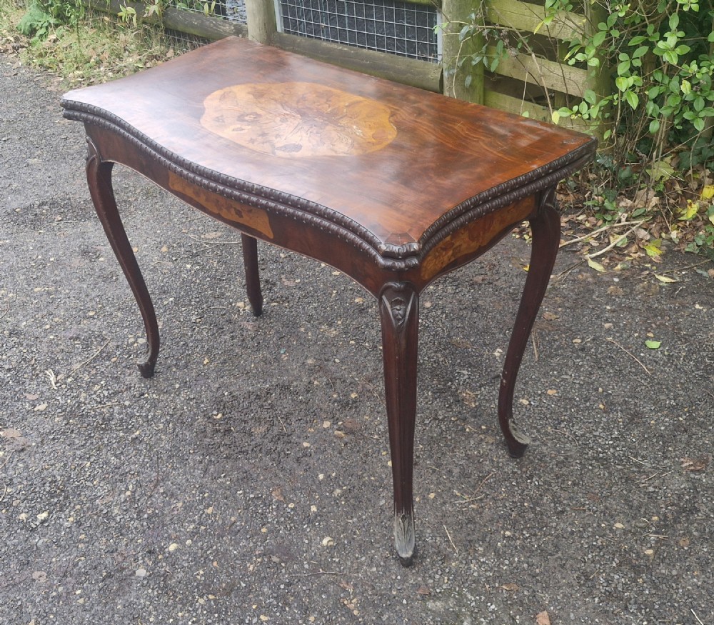 An 18th-century mahogany games table featuring a serpentine front, cabriole legs with carved knees, and marquetry inlay on the top. View VII