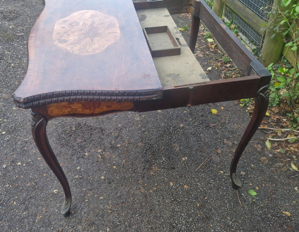 An 18th-century mahogany games table featuring a serpentine front, cabriole legs with carved knees, and marquetry inlay on the top. View VIII