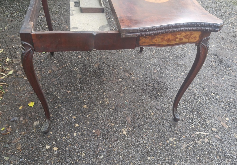 An 18th-century mahogany games table featuring a serpentine front, cabriole legs with carved knees, and marquetry inlay on the top. View XII