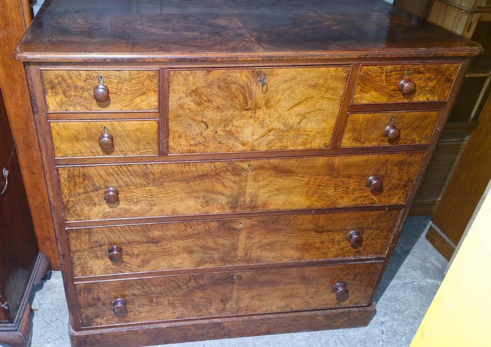 Victorian burr walnut chest of drawers featuring turned timber knobs, multiple small top drawers, and graduating wide drawers. View VII