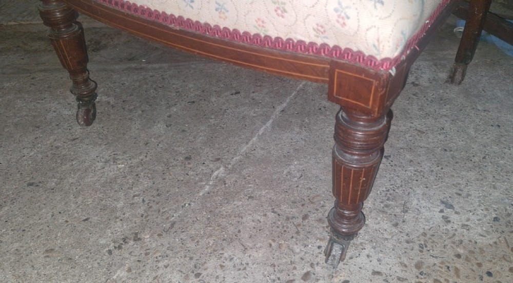 An Edwardian inlaid rosewood bedroom chair with patterned fabric upholstery on the seat and backrest, an inlaid back splat, and turned front legs on castors. View III