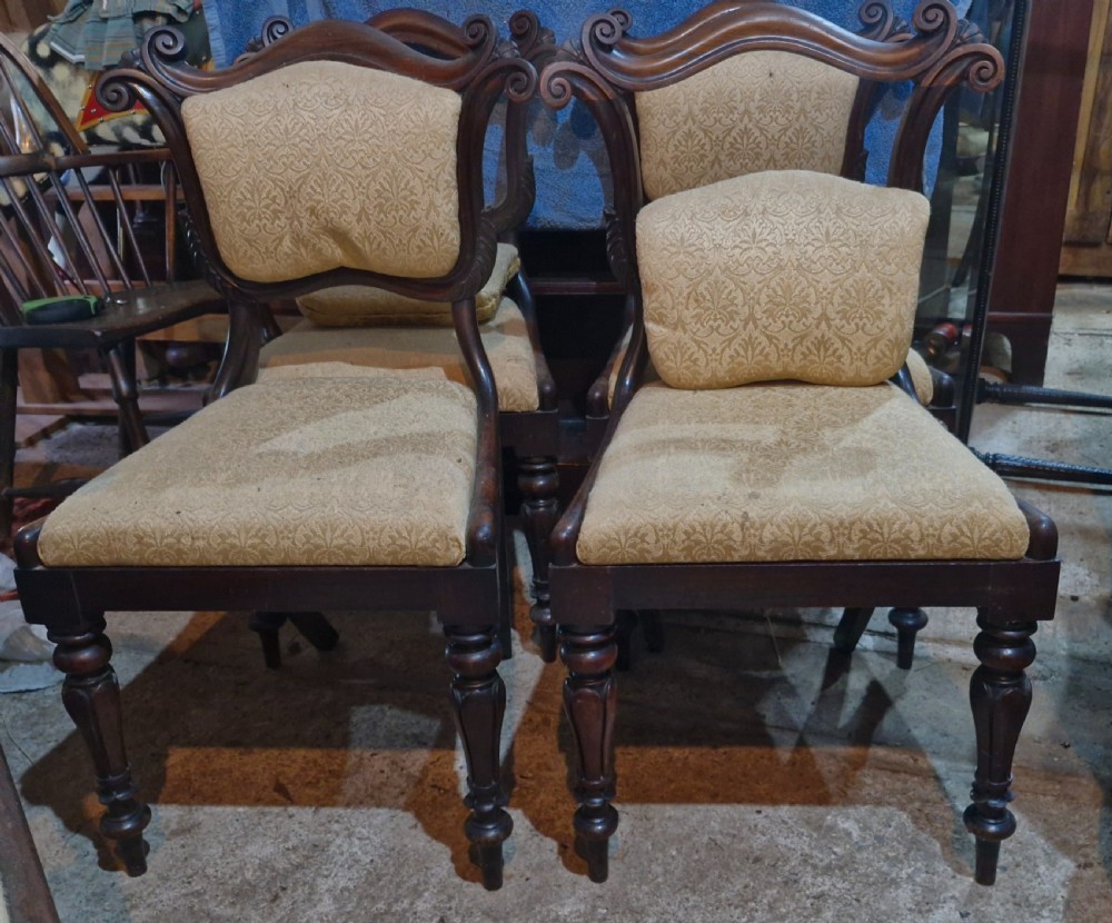 A set of early Victorian rosewood dining chairs with carved scroll crest rails, beige damask upholstered seat and back pads, and turned front legs. View XI