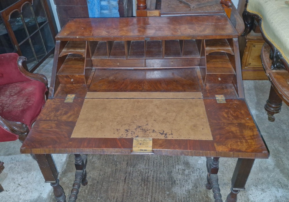 A William and Mary style walnut bureau featuring a slanted fall-front writing flap over three lower drawers, supported on turned legs with cross stretchers. View XII