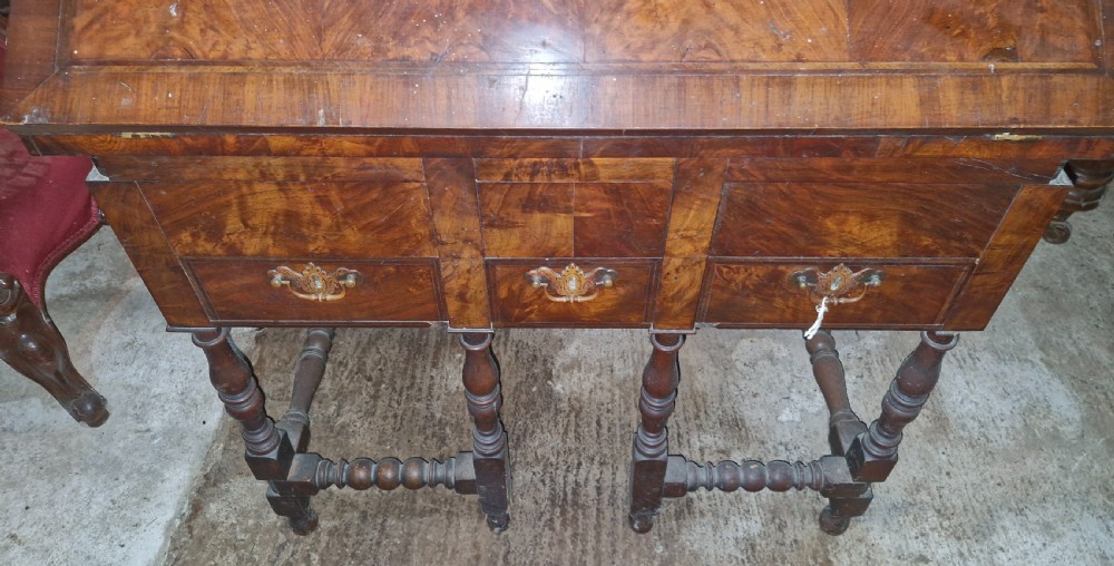 A William and Mary style walnut bureau featuring a slanted fall-front writing flap over three lower drawers, supported on turned legs with cross stretchers. View XIII