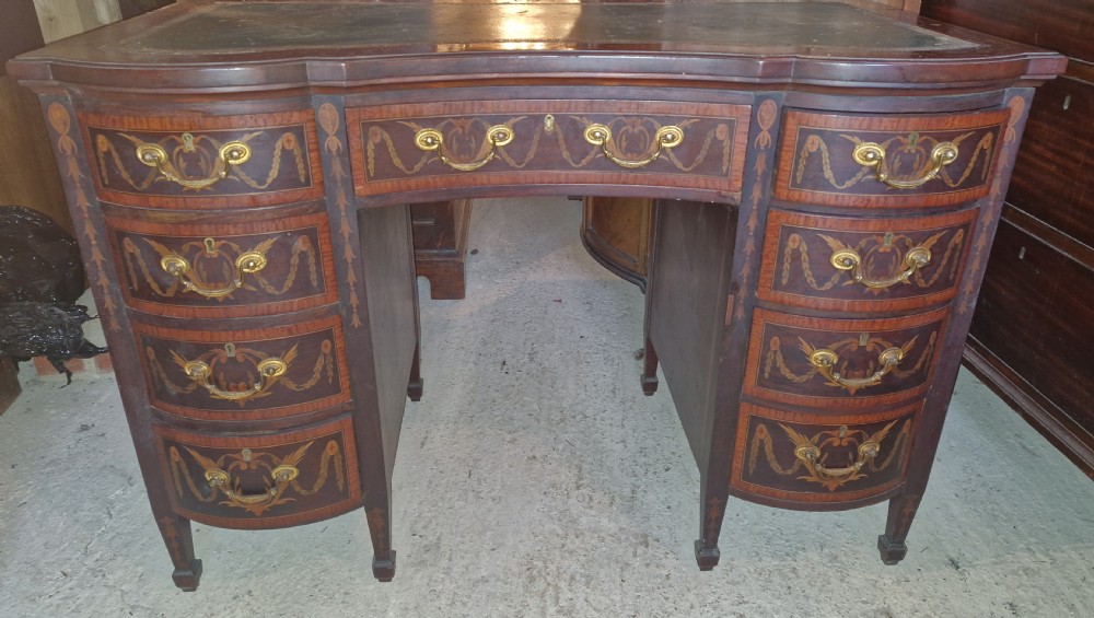 A late Victorian inlaid mahogany kneehole writing desk featuring a green leather insert, multiple drawers with brass handles, and detailed floral marquetry. View XIII