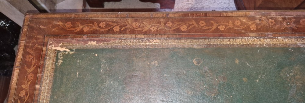 A late Victorian inlaid mahogany kneehole writing desk featuring a green leather insert, multiple drawers with brass handles, and detailed floral marquetry. View XVI