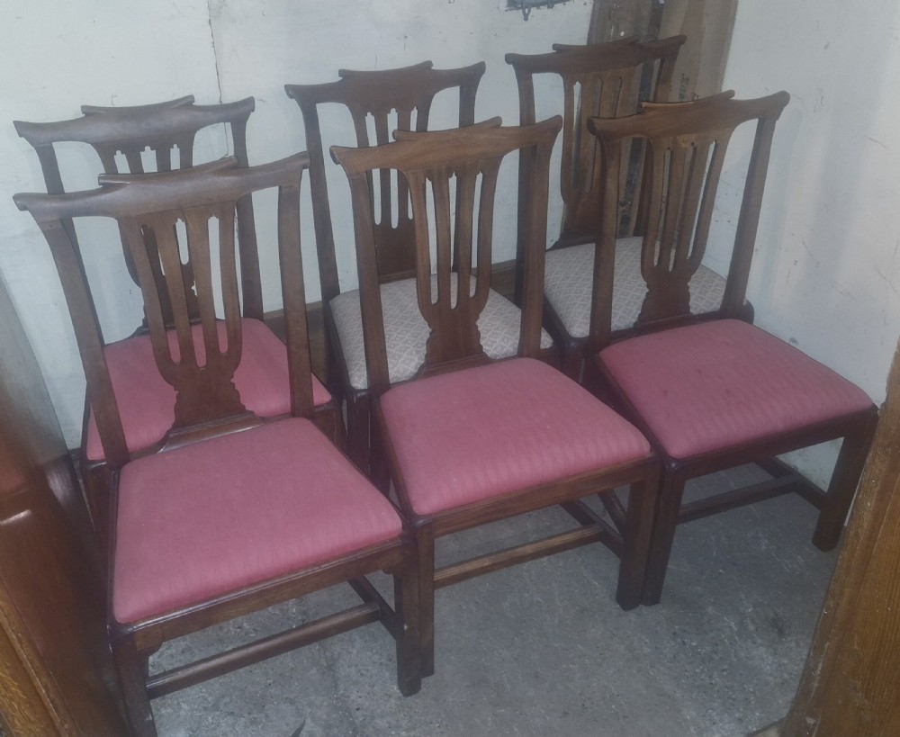 A set of six 18th-century style mahogany dining chairs featuring vertical pierced splats, rectangular backs, and upholstered drop-in seats.