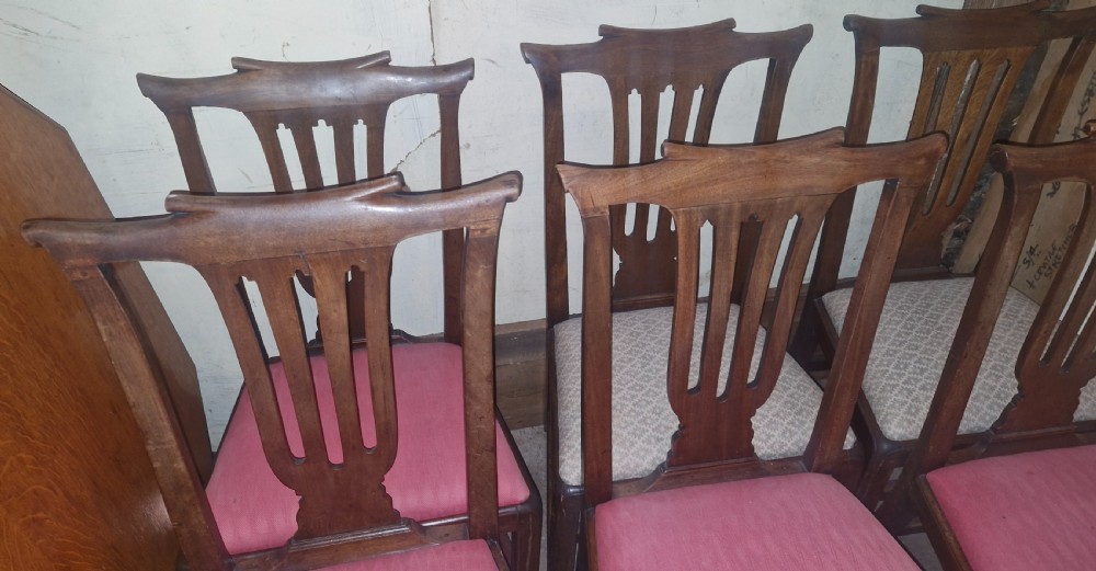 A set of six 18th-century style mahogany dining chairs featuring vertical pierced splats, rectangular backs, and upholstered drop-in seats. View V
