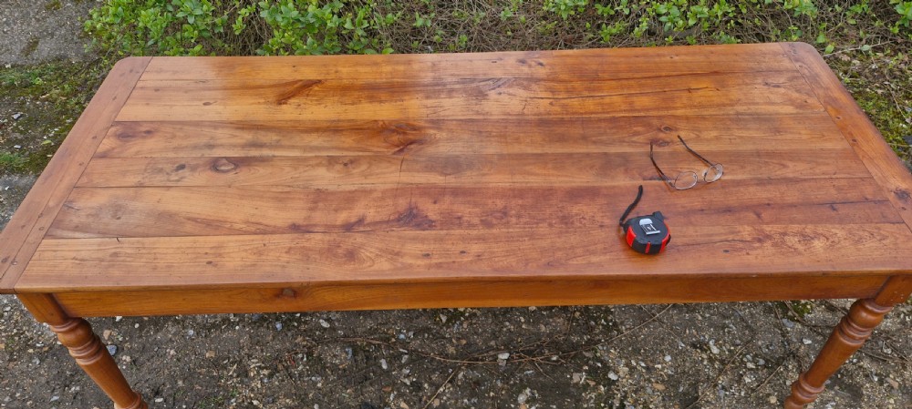 A long rectangular wooden French farmhouse dining table featuring turned legs, an open side drawer, and an extended pull-out bread slide. View XVI