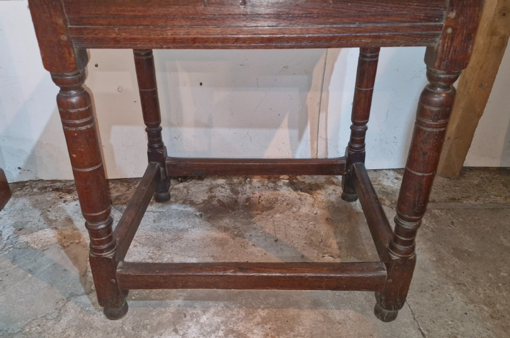An 18th-century dark oak side table featuring a rectangular plank top, turned legs, and lower wooden stretchers. View V