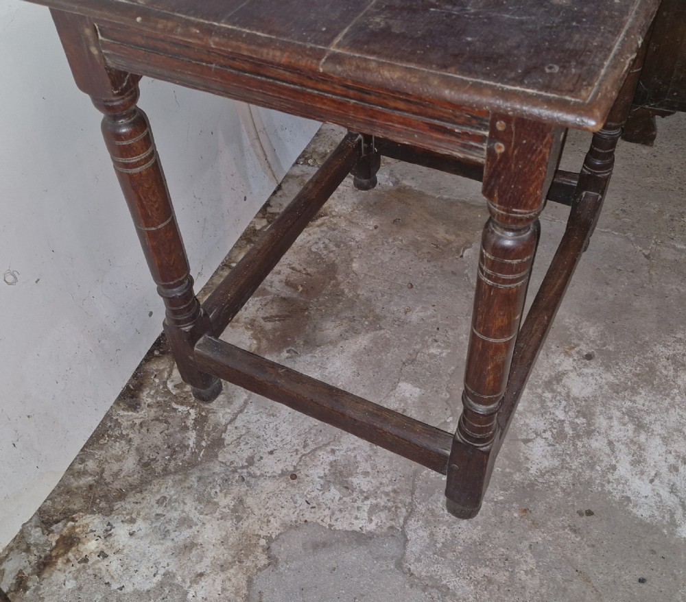 An 18th-century dark oak side table featuring a rectangular plank top, turned legs, and lower wooden stretchers. View VII