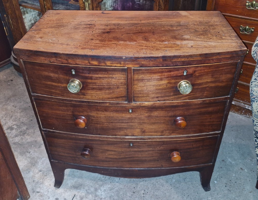A Regency mahogany bowfront chest of drawers featuring two short over two long drawers set on splayed feet.