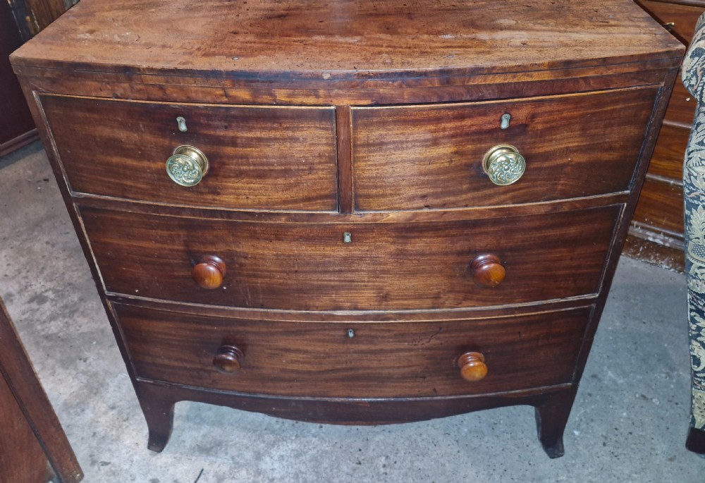 A Regency mahogany bowfront chest of drawers featuring two short over two long drawers set on splayed feet. View II