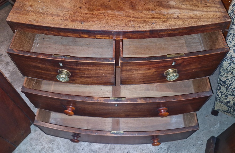 A Regency mahogany bowfront chest of drawers featuring two short over two long drawers set on splayed feet. View V