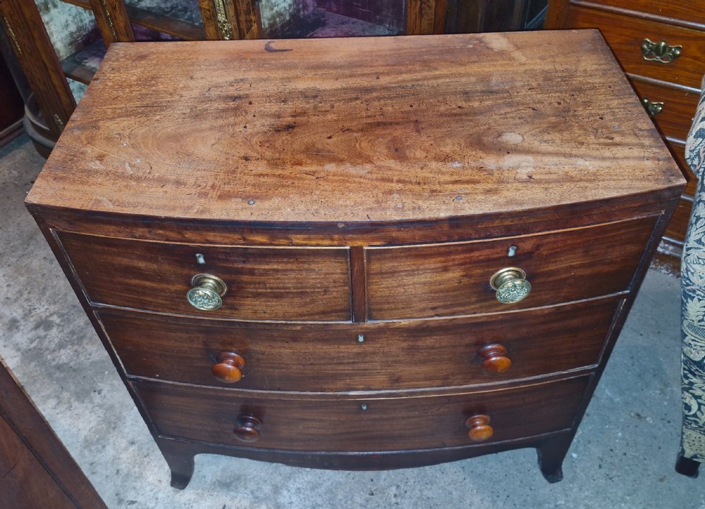 A Regency mahogany bowfront chest of drawers featuring two short over two long drawers set on splayed feet. View VI