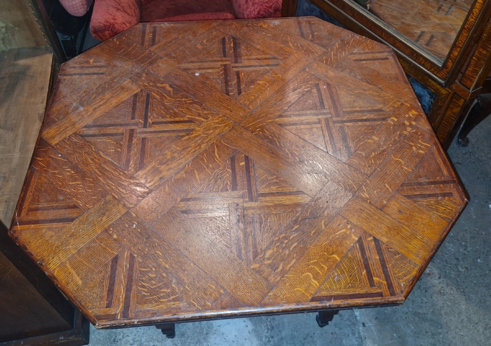 An octagonal late Victorian hall table featuring a geometric inlaid parquetry wood top supported by turned legs and cross stretchers. View III