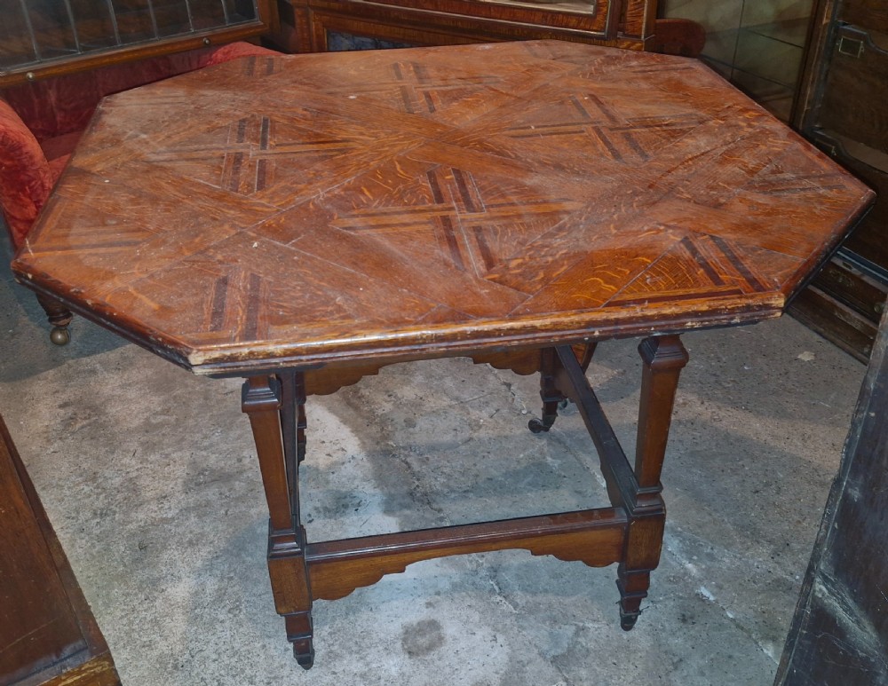 An octagonal late Victorian hall table featuring a geometric inlaid parquetry wood top supported by turned legs and cross stretchers. View IV