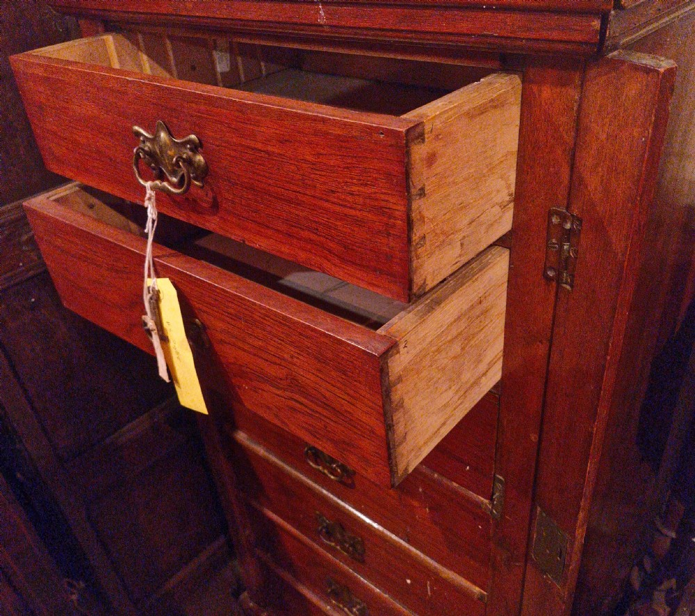 A tall, narrow Victorian walnut Wellington chest featuring seven graduated drawers with decorative brass handles and a side locking bar. View II
