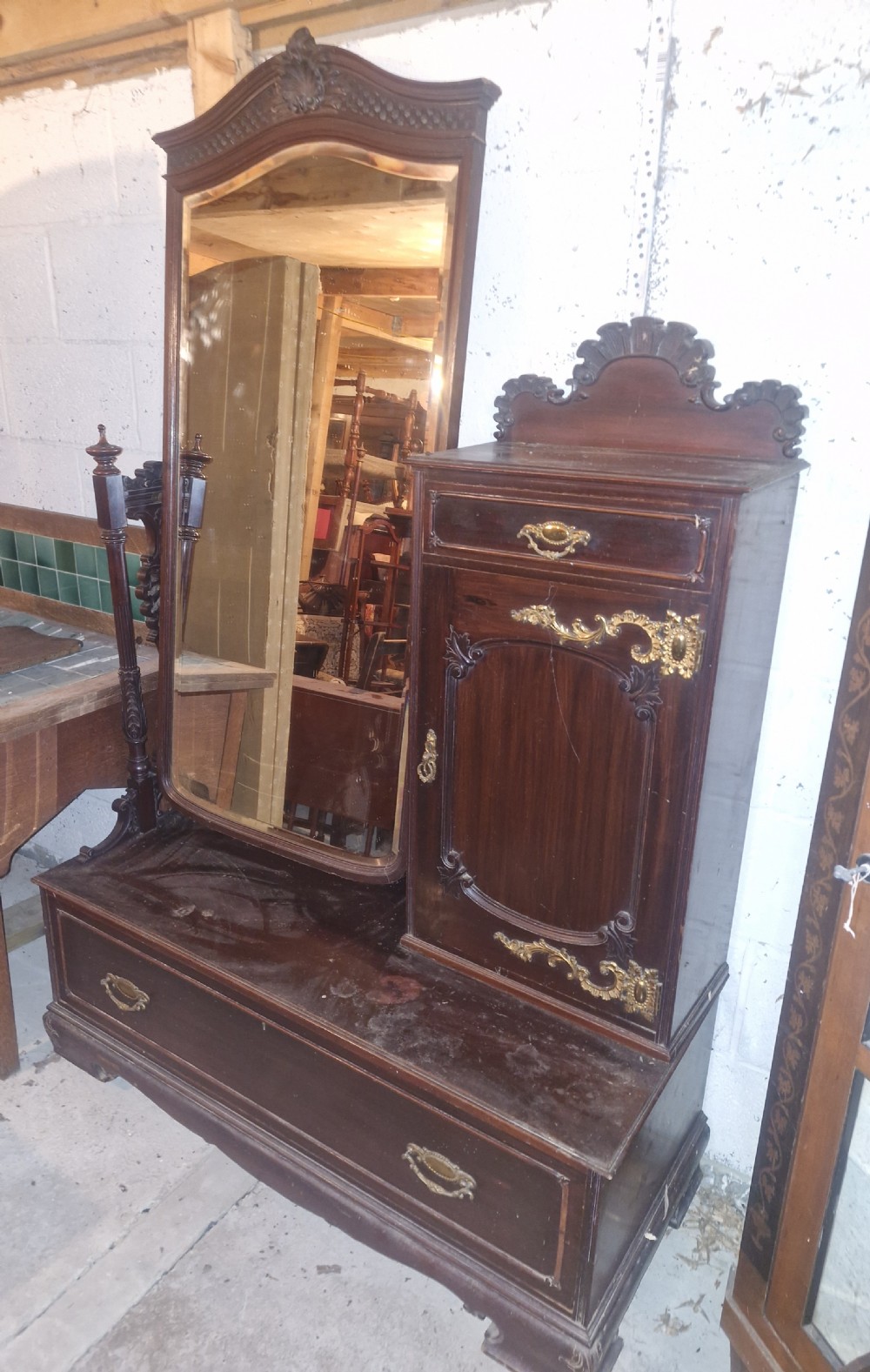 A late Victorian dark mahogany dressing table featuring a tall central mirror, carved top pediment, attached side cupboard with brass mounts, and a lower wide drawer. View II